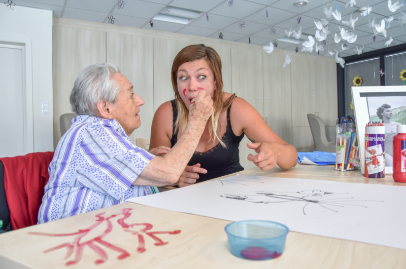 Deux femmes sont assises à une table et discutent entre elles.