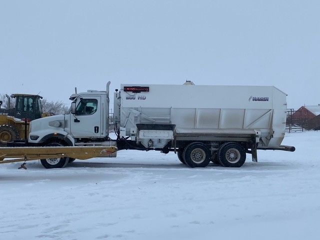 White truck with salt spreader in a snowy field at Coro View Farms Ltd.