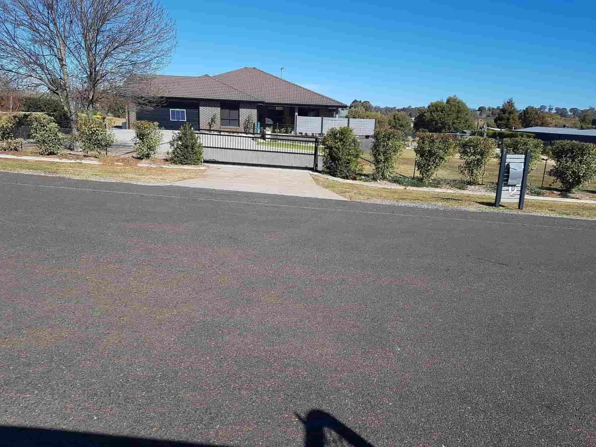 A House Is Sitting On The Side Of The Road Next To A Road — Anne & Ron Johnson Fencing in Werris Creek, NSW