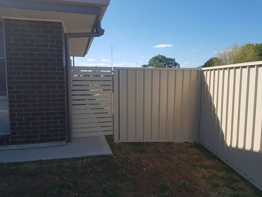 A Fence With A Gate Set Up In Front Of A House — Anne & Ron Johnson Fencing in Werris Creek, NSW