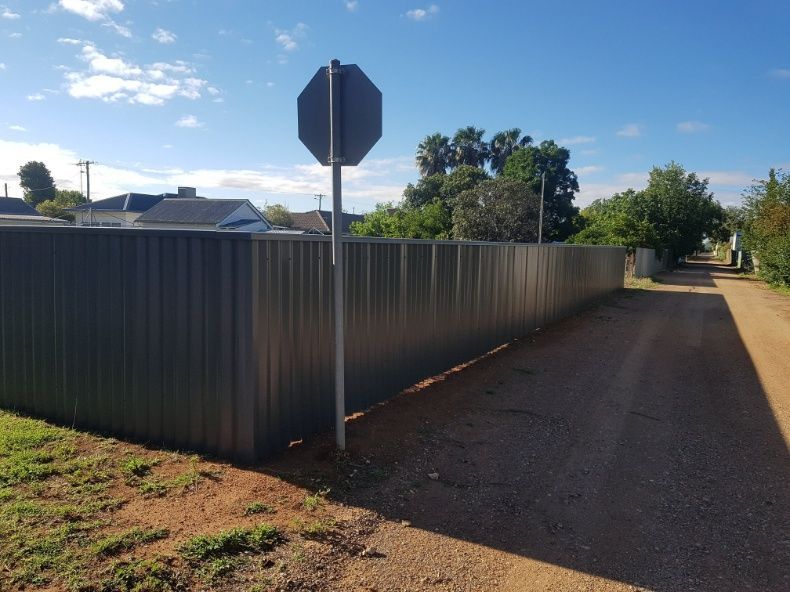 A Fence Stands Tall With A Bright Red Stop Sign — Anne & Ron Johnson Fencing in Werris Creek, NSW