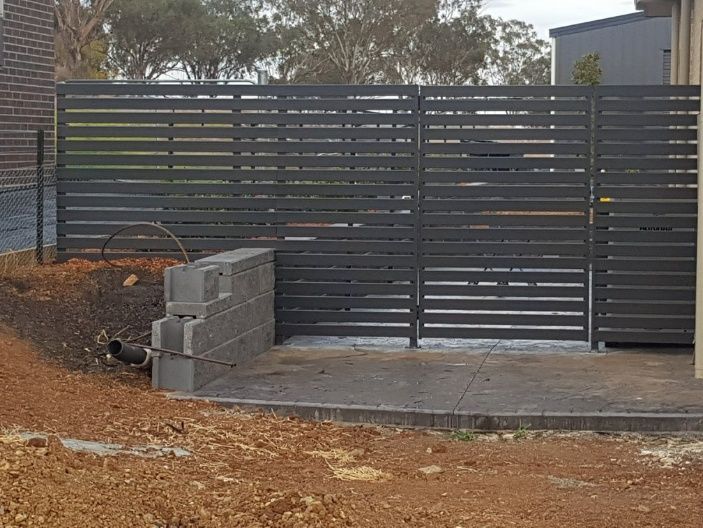 A Slat Fence Build In Front Of A House — Anne & Ron Johnson Fencing in Werris Creek, NSW