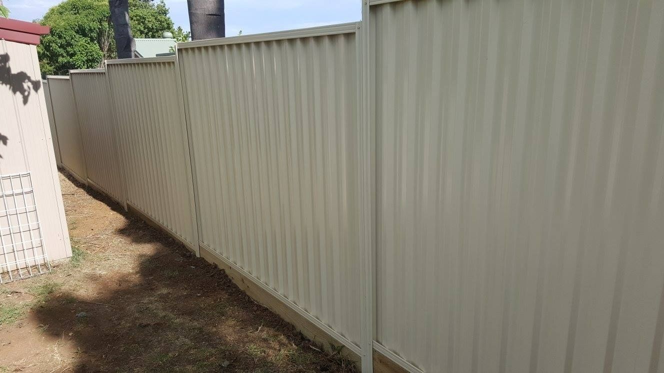 Long Beige Metal Fence With Vertical Panels — Anne & Ron Johnson Fencing in Werris Creek, NSW