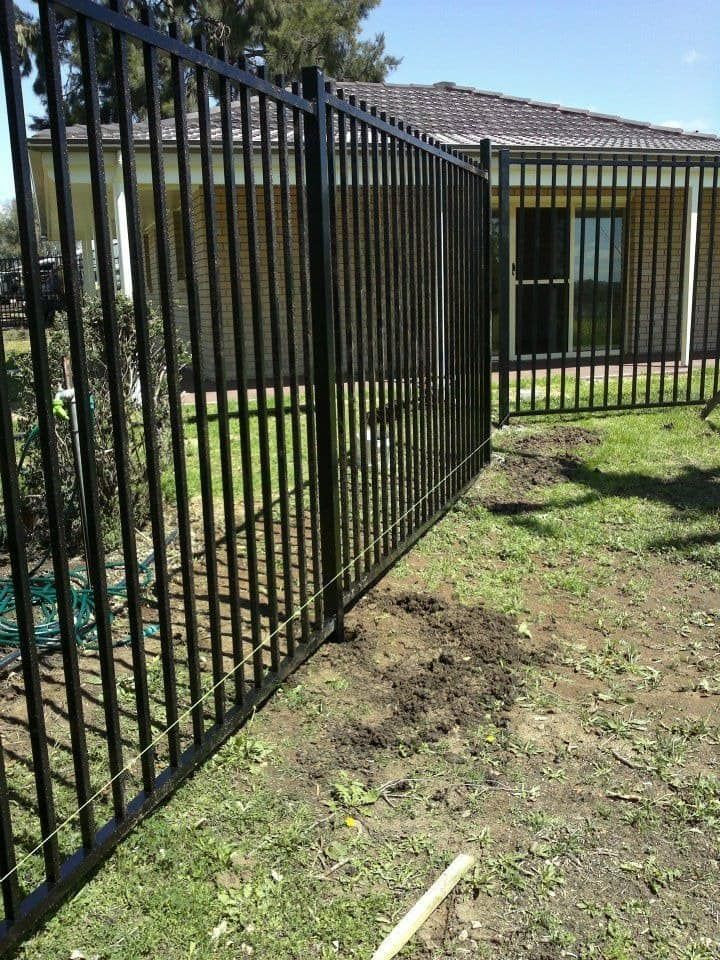 A Black Metal Fence Is In Front Of A House — Anne & Ron Johnson Fencing in Scone, NSW