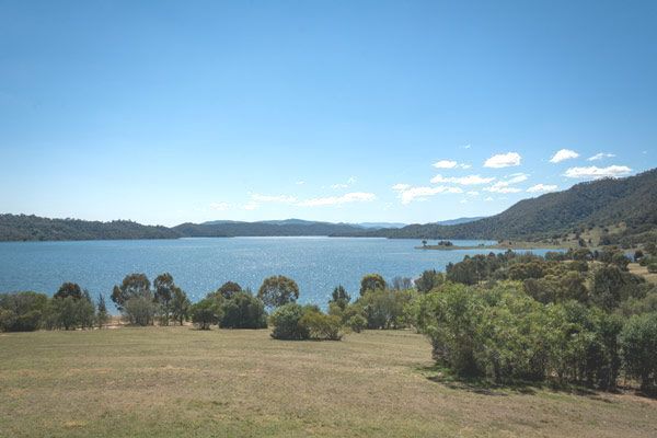 A Large Body of Water Surrounded by Trees and Mountains on a Sunny Day — Anne & Ron Johnson Fencing in Scone, NSW