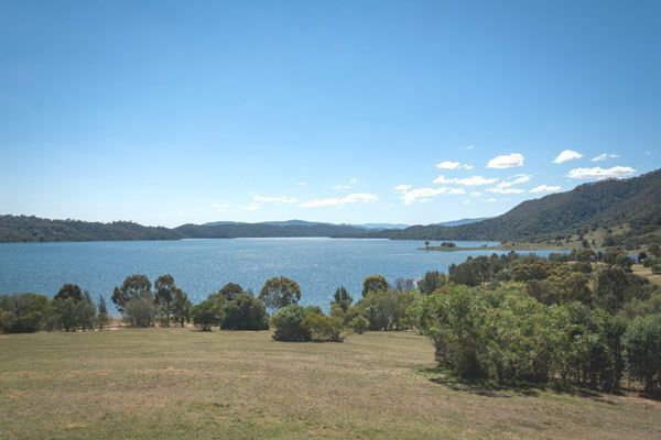 A Large Body of Water Surrounded by Trees and Mountains on a Sunny Day — Anne & Ron Johnson Fencing in Scone, NSW