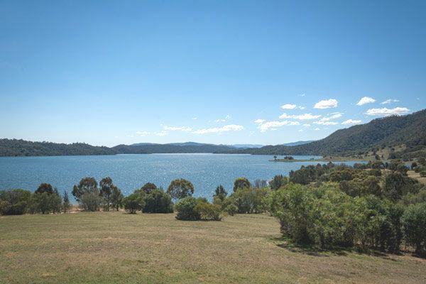 A Large Body of Water Surrounded by Trees and Mountains on a Sunny Day — Anne & Ron Johnson Fencing in Scone, NSW
