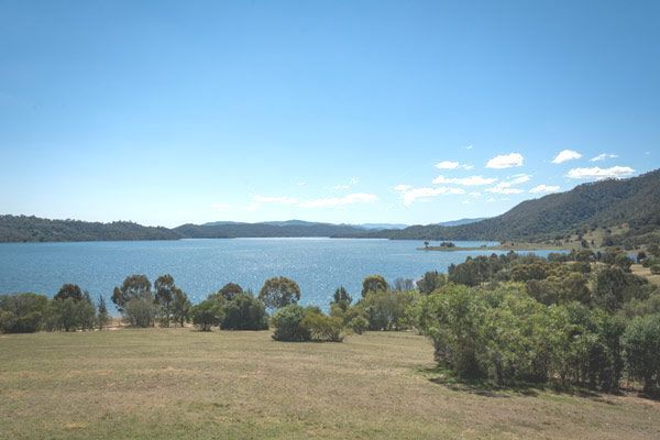 A Large Body of Water Surrounded by Trees and Mountains on a Sunny Day — Anne & Ron Johnson Fencing in Scone, NSW