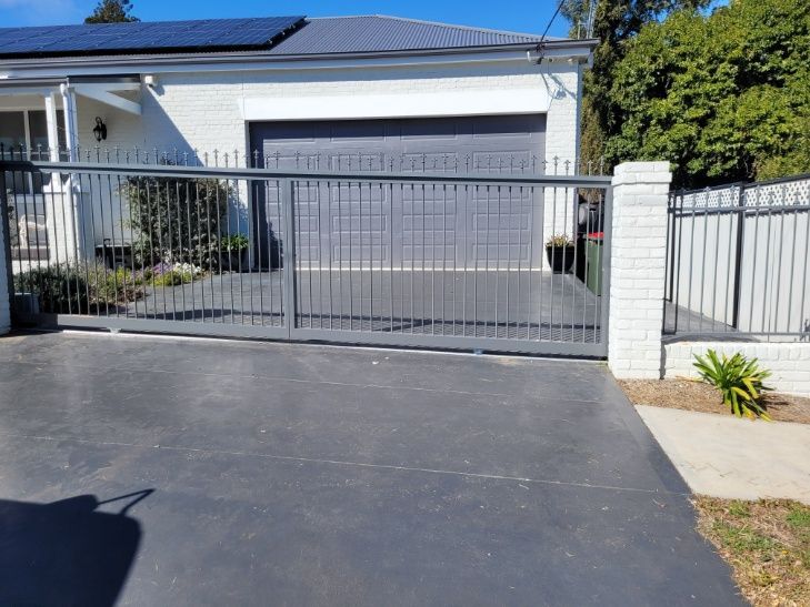 A Driveway Featuring An Auto Gate And Solar Panels On The Side — Anne & Ron Johnson Fencing in Werris Creek, NSW