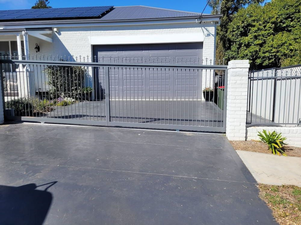 A House With A Sliding Gate In Front Of It — Anne & Ron Johnson Fencing in Quirindi, NSW
