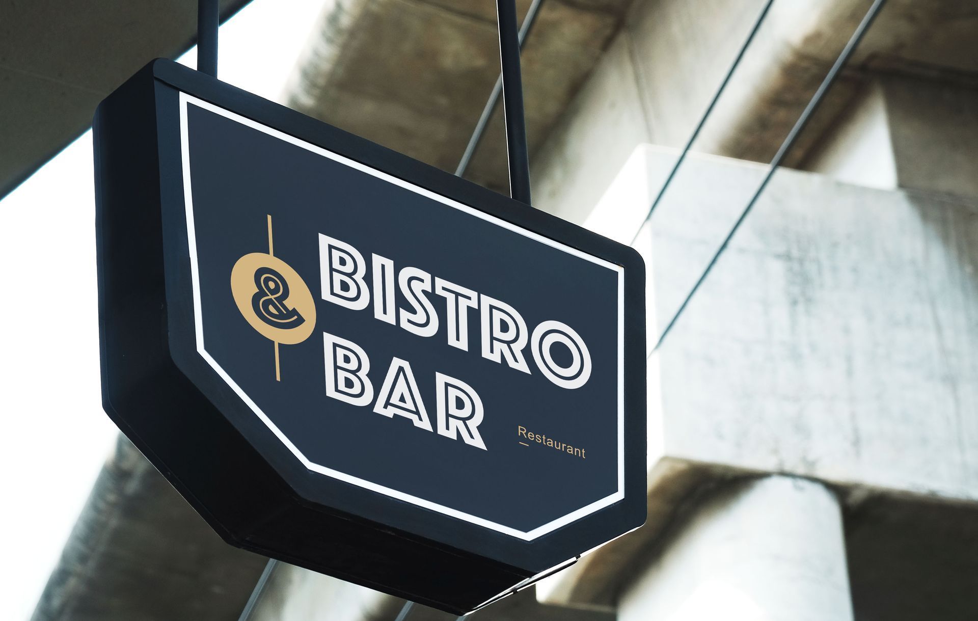 Black hanging sign reading “BISTRO BAR” with a small fork-and-spoon icon against a building backdrop