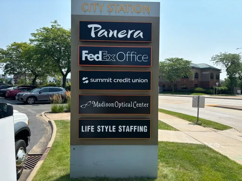 Outdoor shopping center sign listing Panera, FedEx Office, Summit Credit Union, and Life Style Staffing