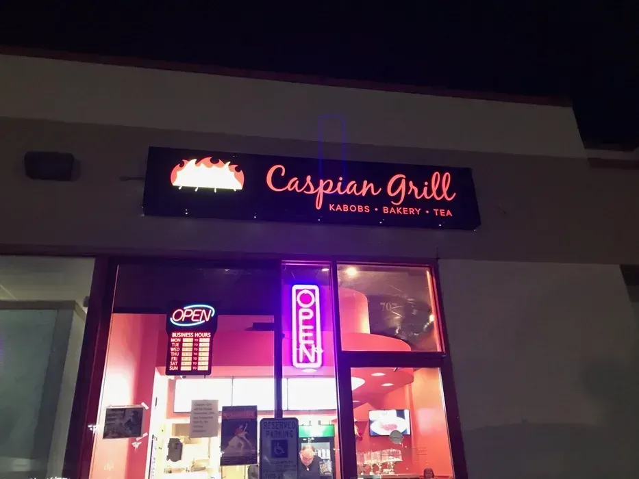 Caspian Grill storefront at night with glowing neon sign and lit entrance