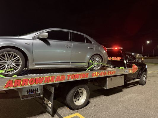 A car is sitting on top of a tow truck.