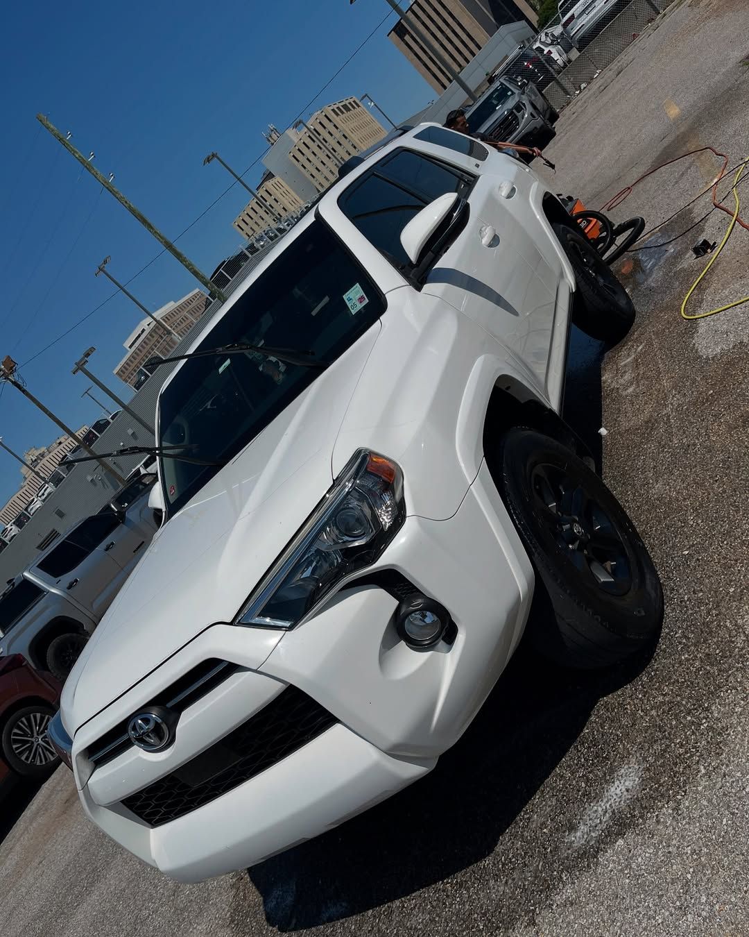 A white toyota 4runner is parked in a parking lot