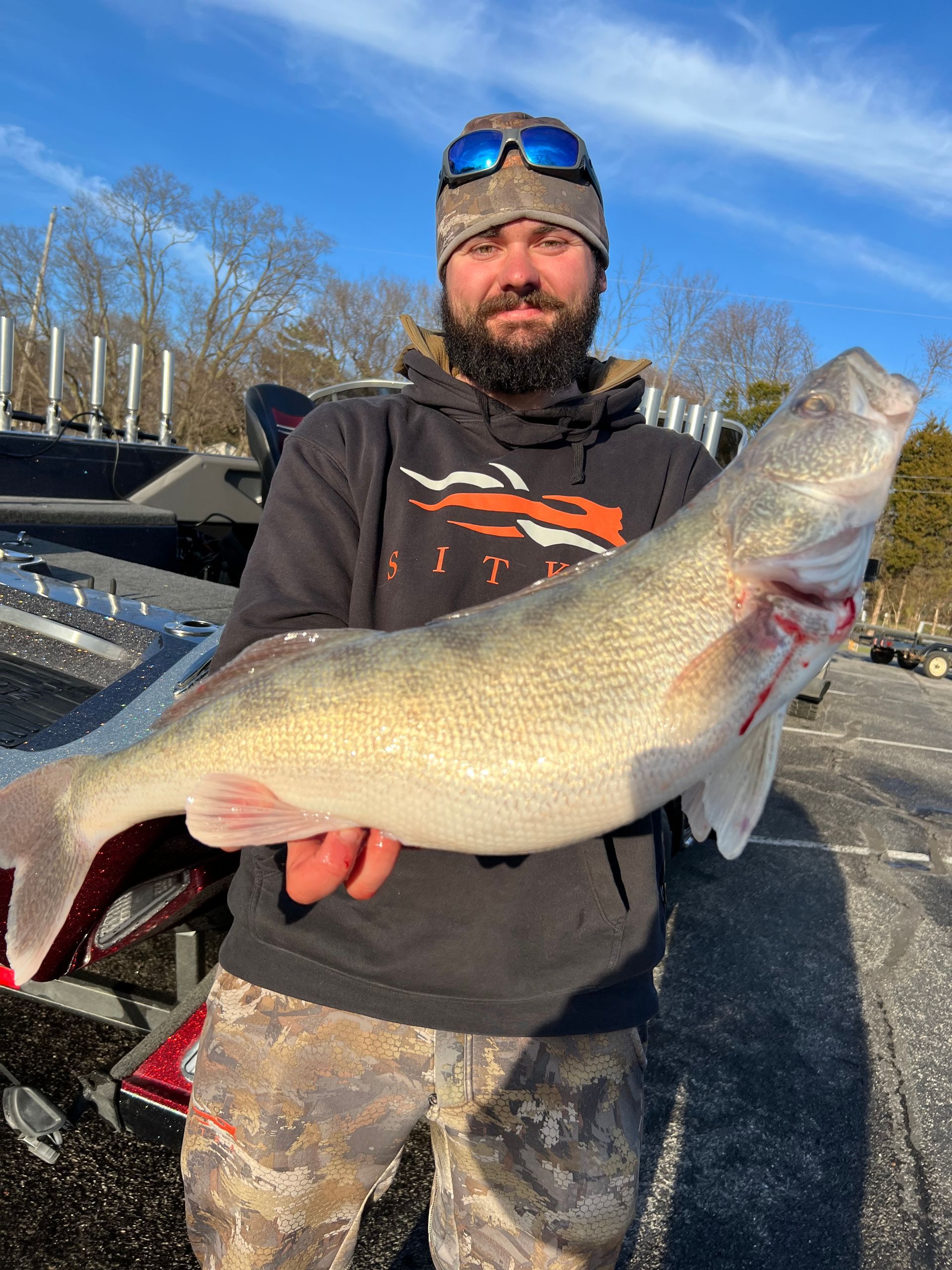 A man is holding a large fish in his hands.