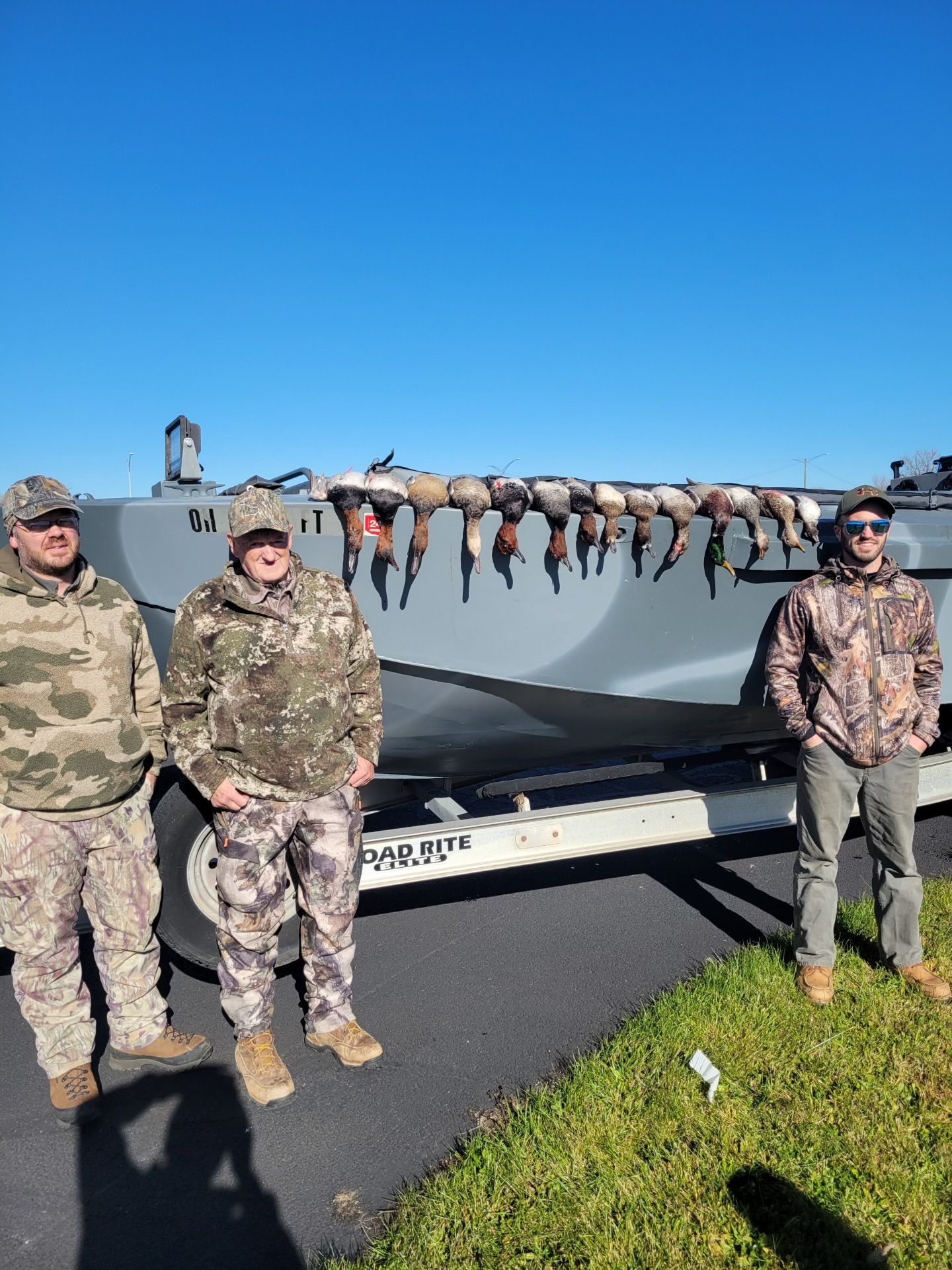A group of men are standing in front of a boat.