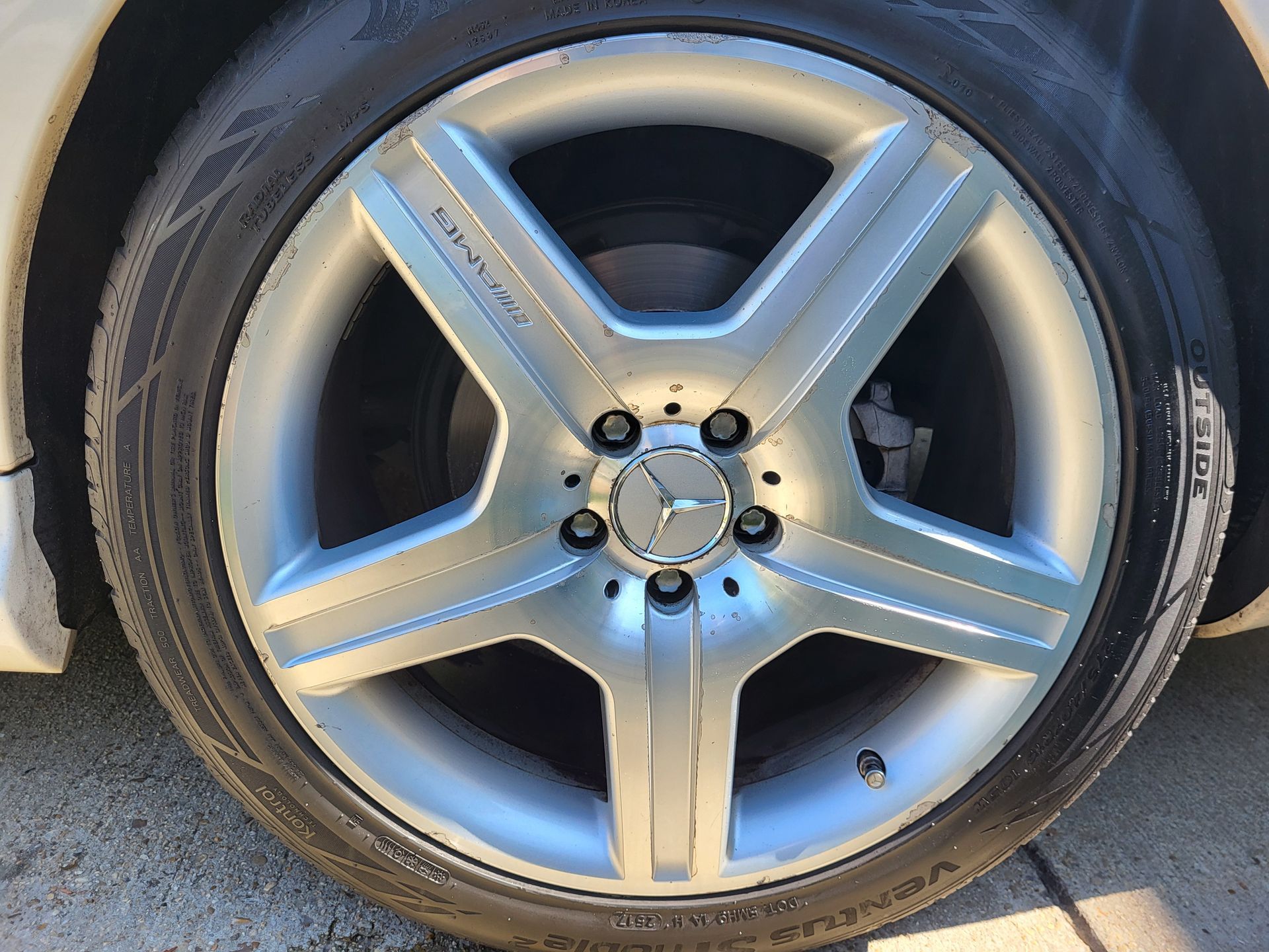 A close up of a mercedes wheel with a tire on it.