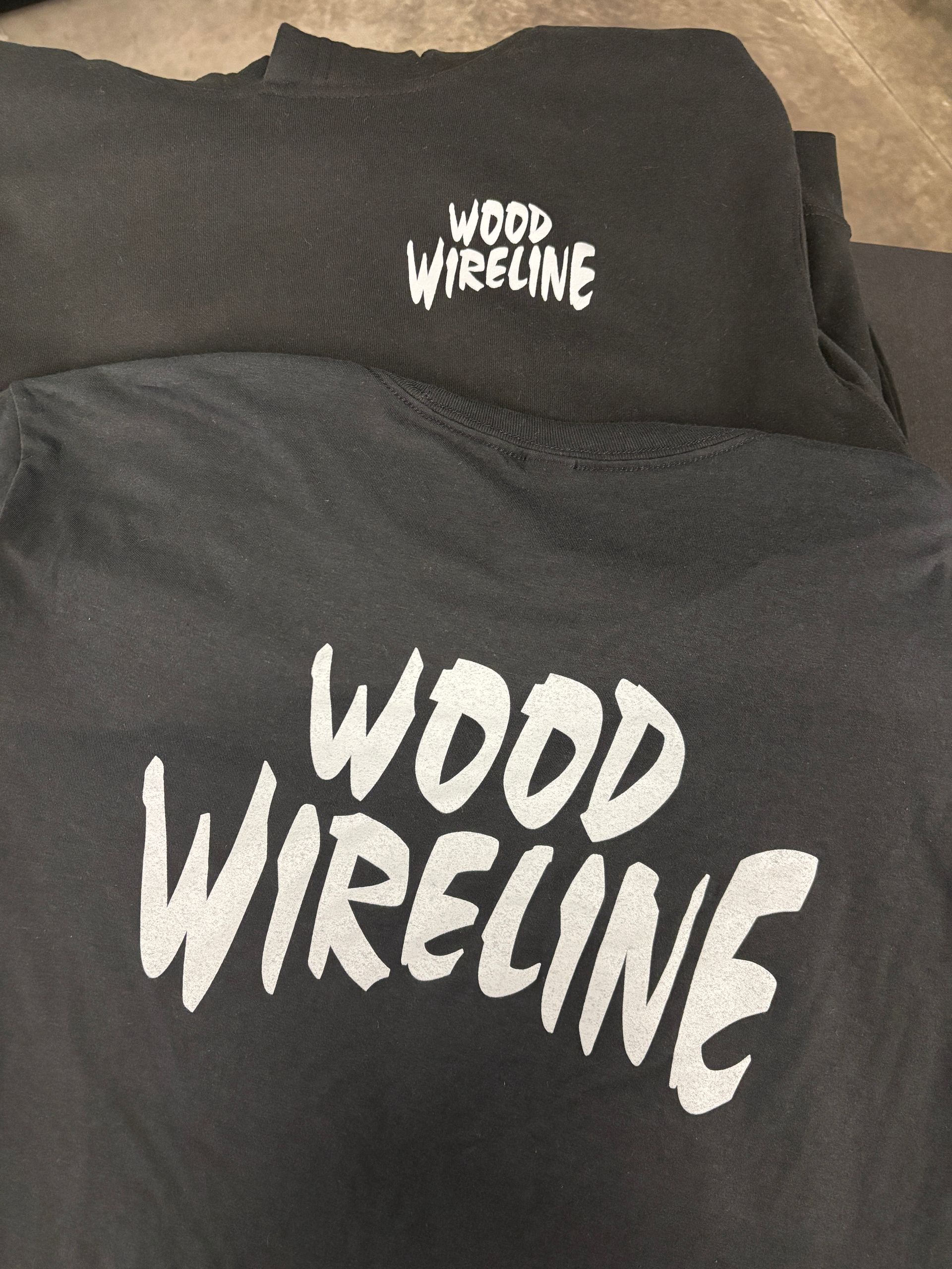Black sweatshirt with white “WOOD WRECKLINE” text on the chest and a matching logo above it