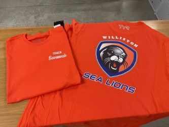 Orange Sea Lions T-shirt with bulldog logo and “Wellington” on a tiled floor