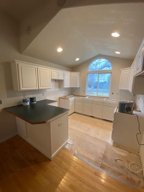 A kitchen with white cabinets and a black counter top.