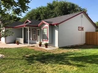 A small white house with a red trim and a porch.