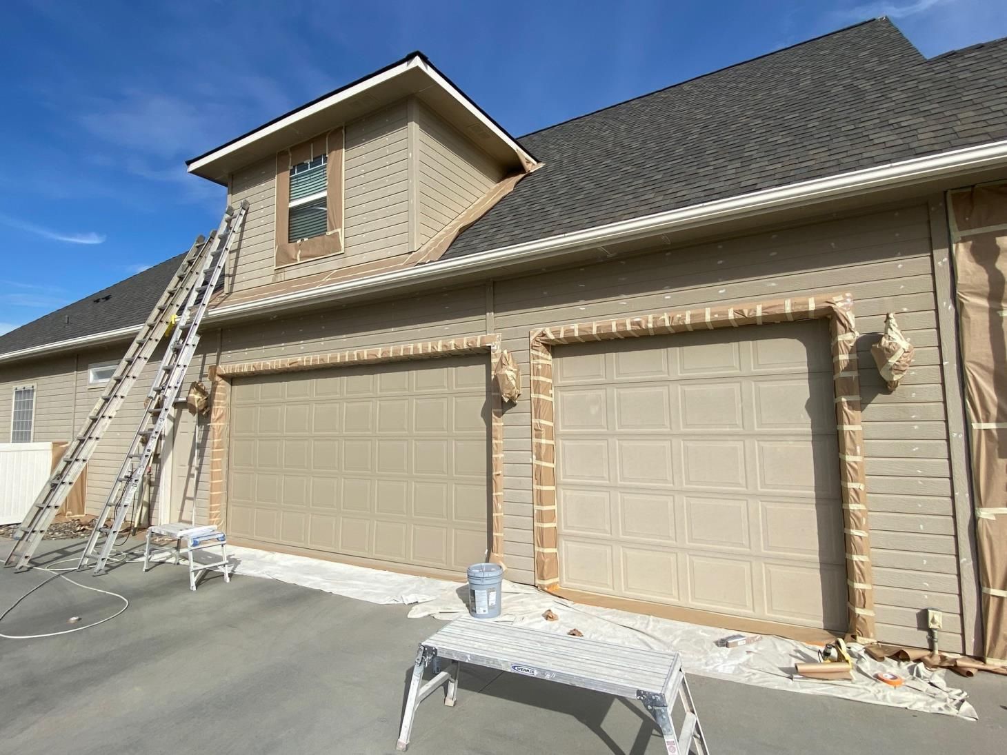 A house is being painted with a ladder on top of it.