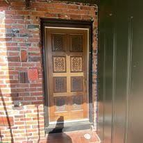 A wooden door is sitting on top of a brick wall.