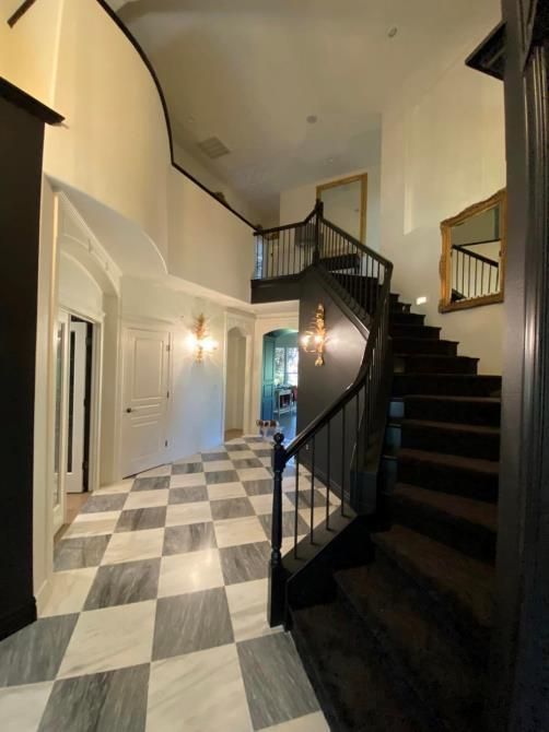 A staircase in a hallway with a checkered floor