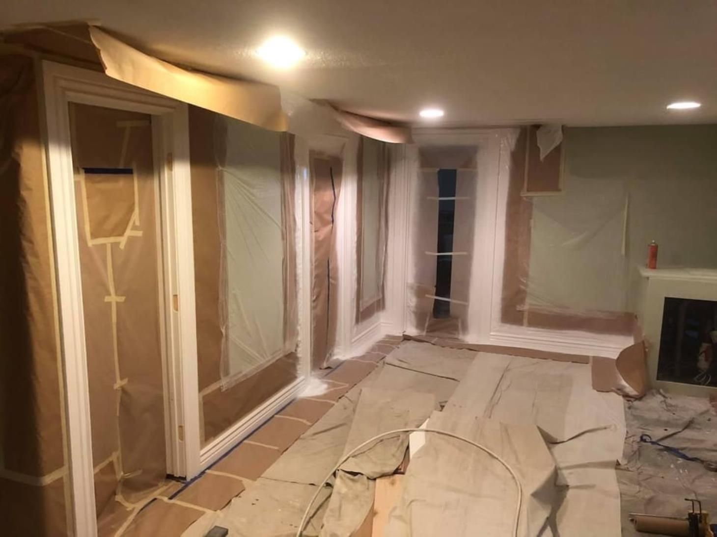 A room with a couch and a fireplace is being painted.