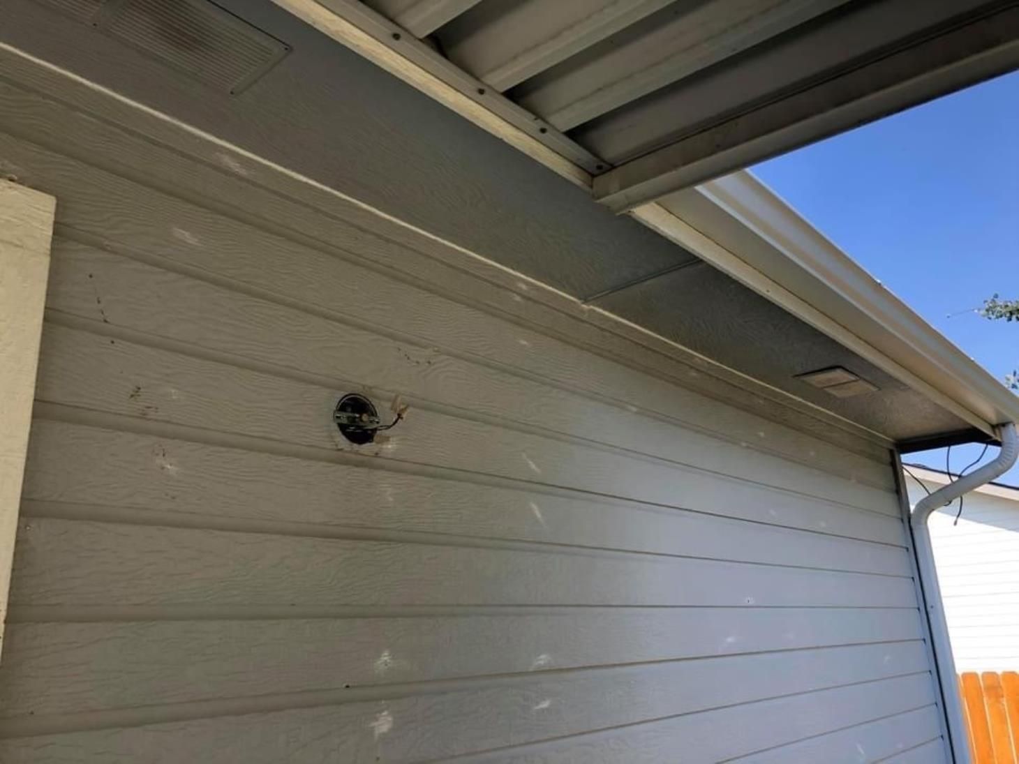 A close up of the side of a house with a roof and gutter.