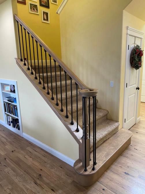 A wooden staircase with a metal railing in a house