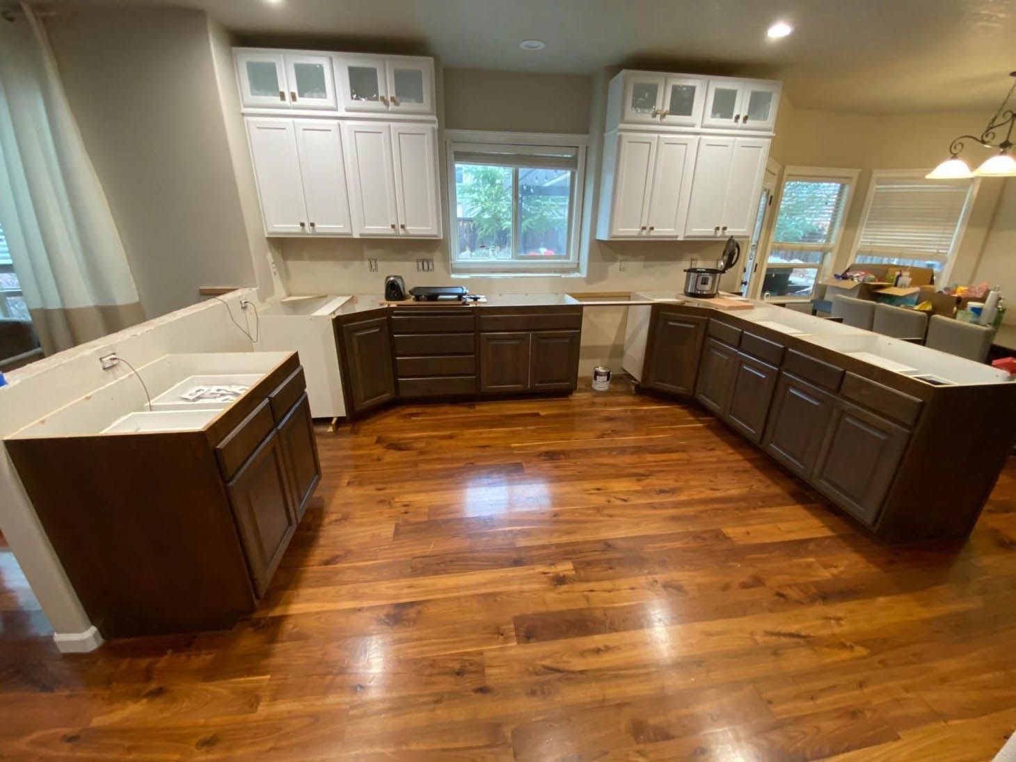 A kitchen with hardwood floors and white cabinets.