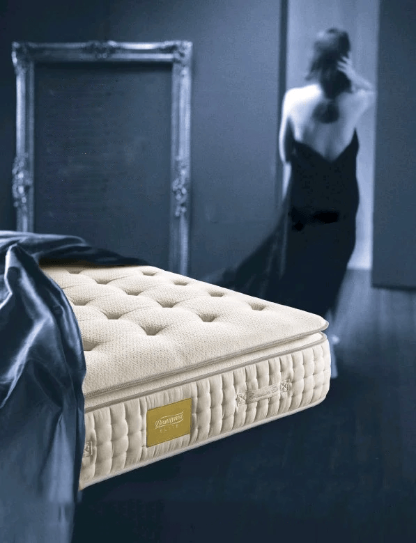 Materasso lussuoso con trapuntatura a bottoni, donna in abito da sera, specchio decorato.