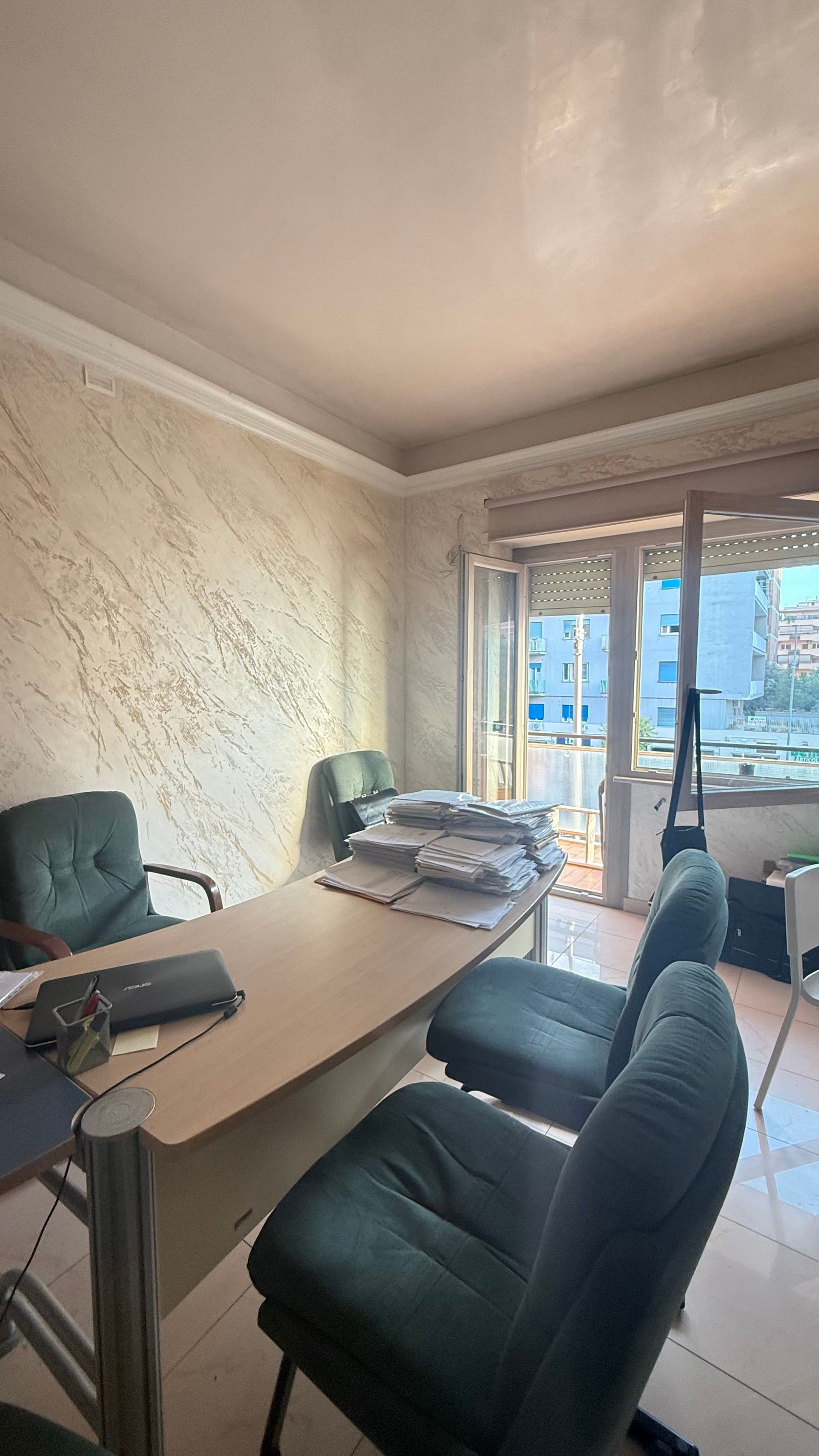 Un ufficio con una scrivania, sedie e una finestra con vista sulla città.