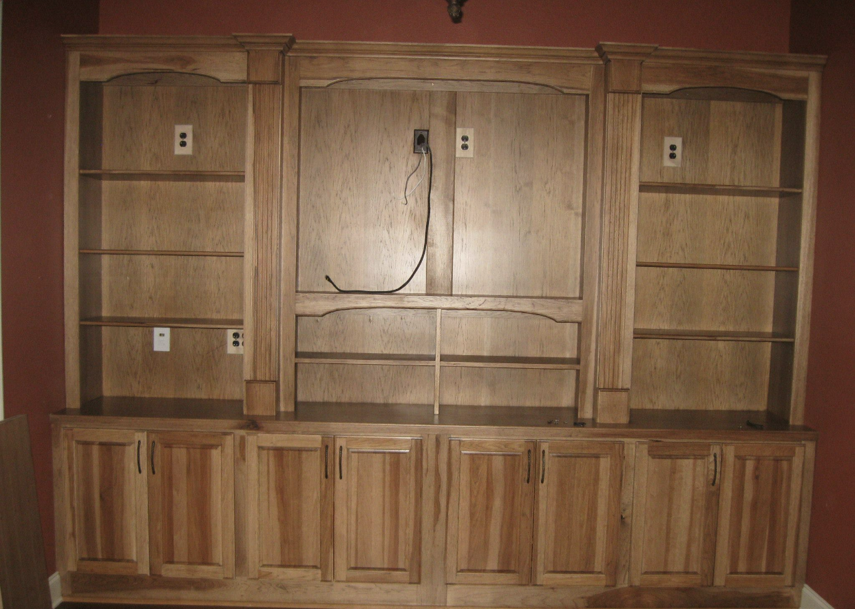 A large wooden entertainment center with shelves and cabinets
