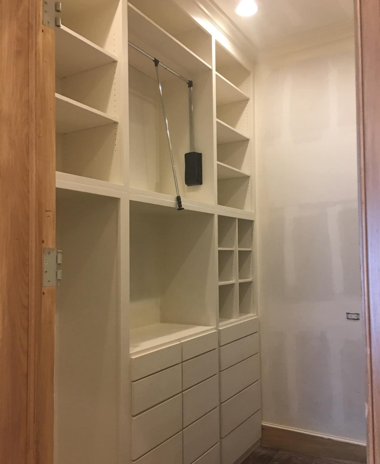 A walk in closet with lots of shelves and drawers.