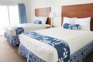 A hotel room with two beds and a lamp