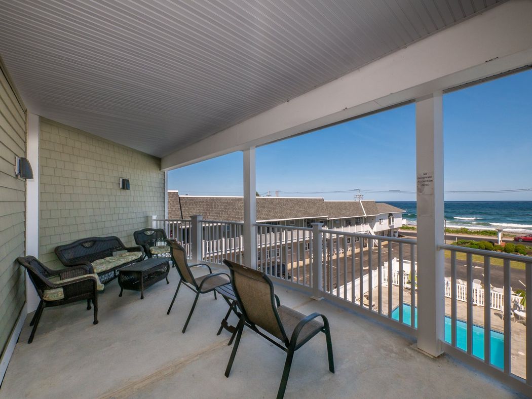 A balcony with a view of the ocean and a pool