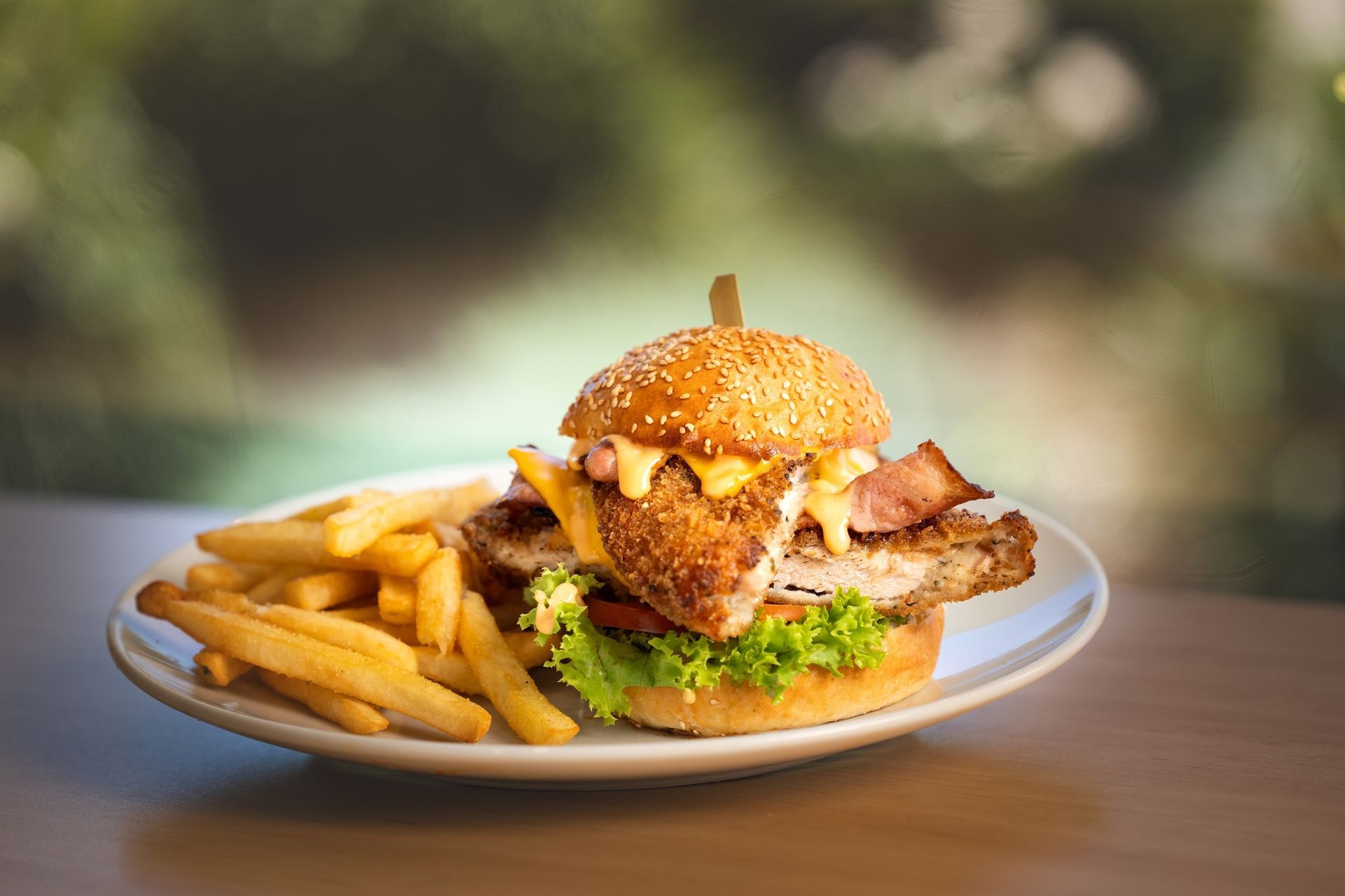 A hamburger and french fries on a white plate on a table.