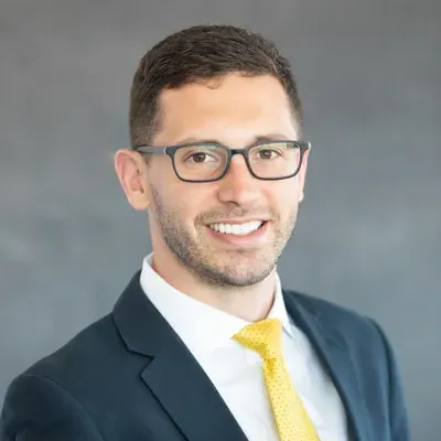 A man in a suit and tie is smiling for the camera.