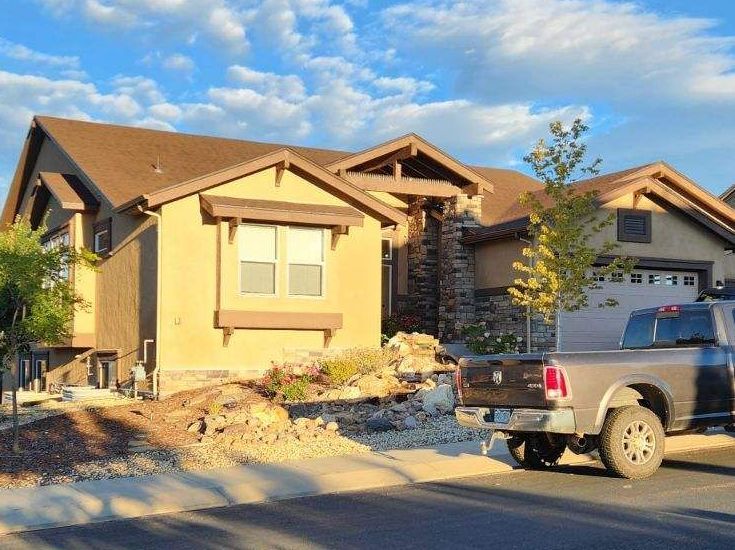 A truck is parked in front of a house.
