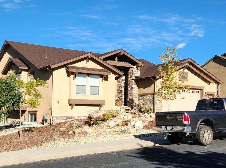 A truck is parked in front of a large house
