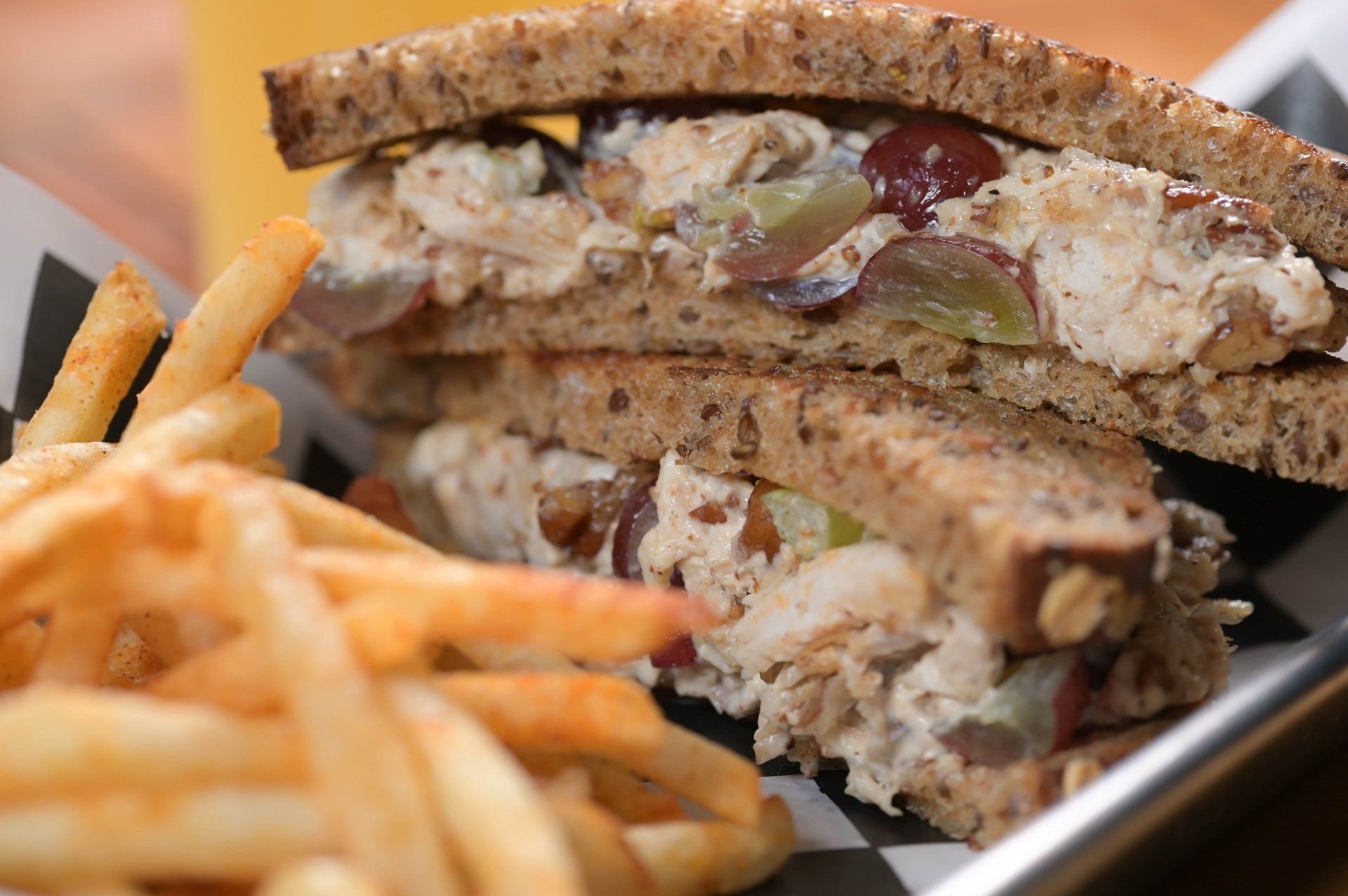 A close up of a sandwich and french fries on a plate.