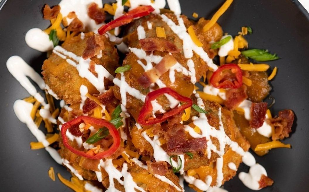 A close up of a plate of food with sauce and cheese on a table.