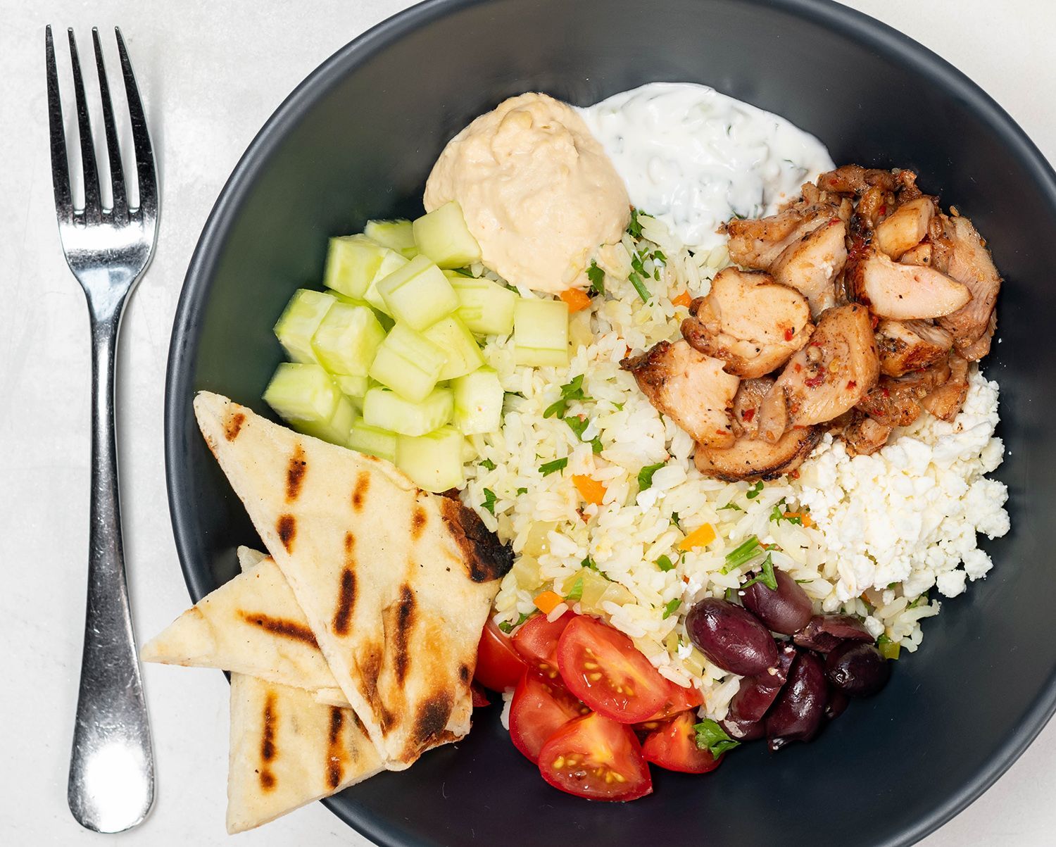 A bowl of food with a fork next to it