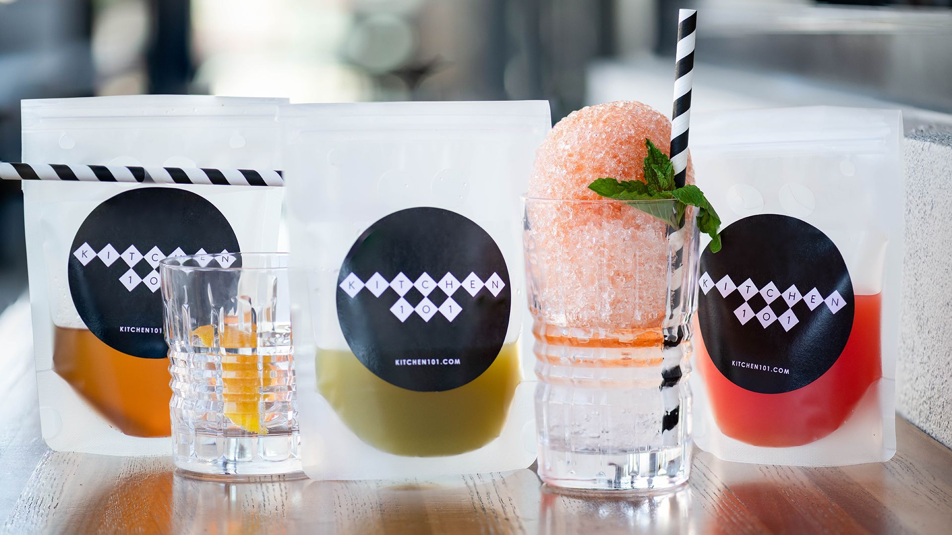 A table topped with glasses , bags , and straws.