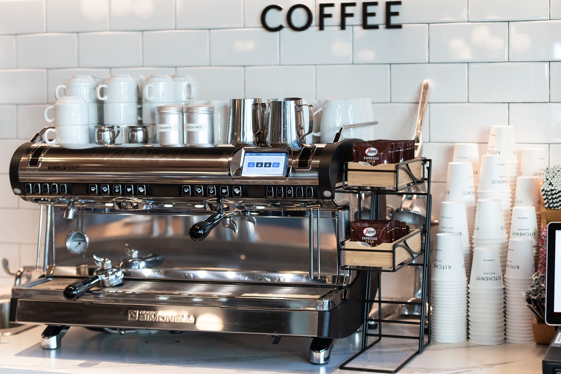 A coffee machine is sitting on a counter next to a sign that says coffee.