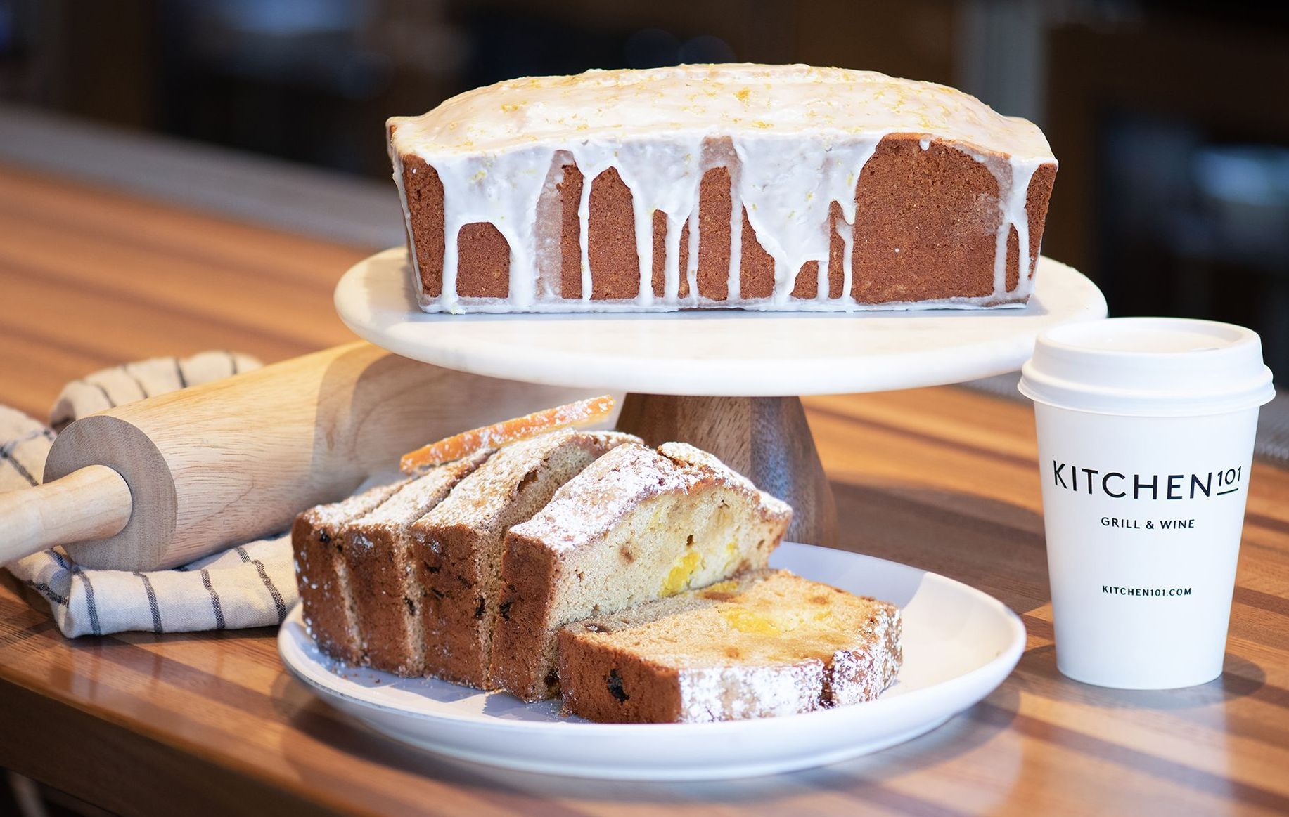 A loaf of bread is on a plate next to a cup of coffee.