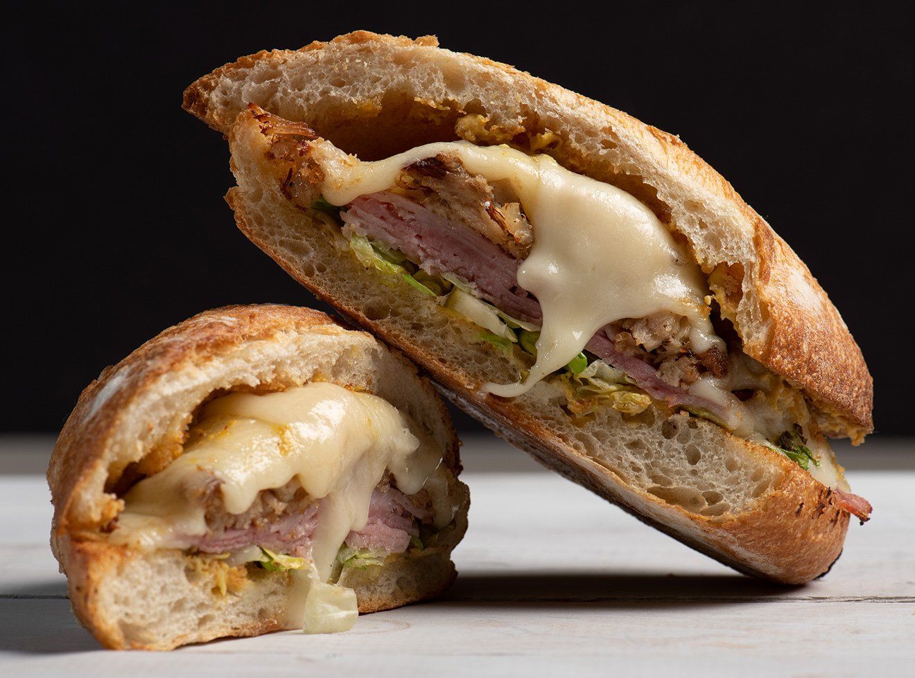 A sandwich is cut in half and sitting on a table.